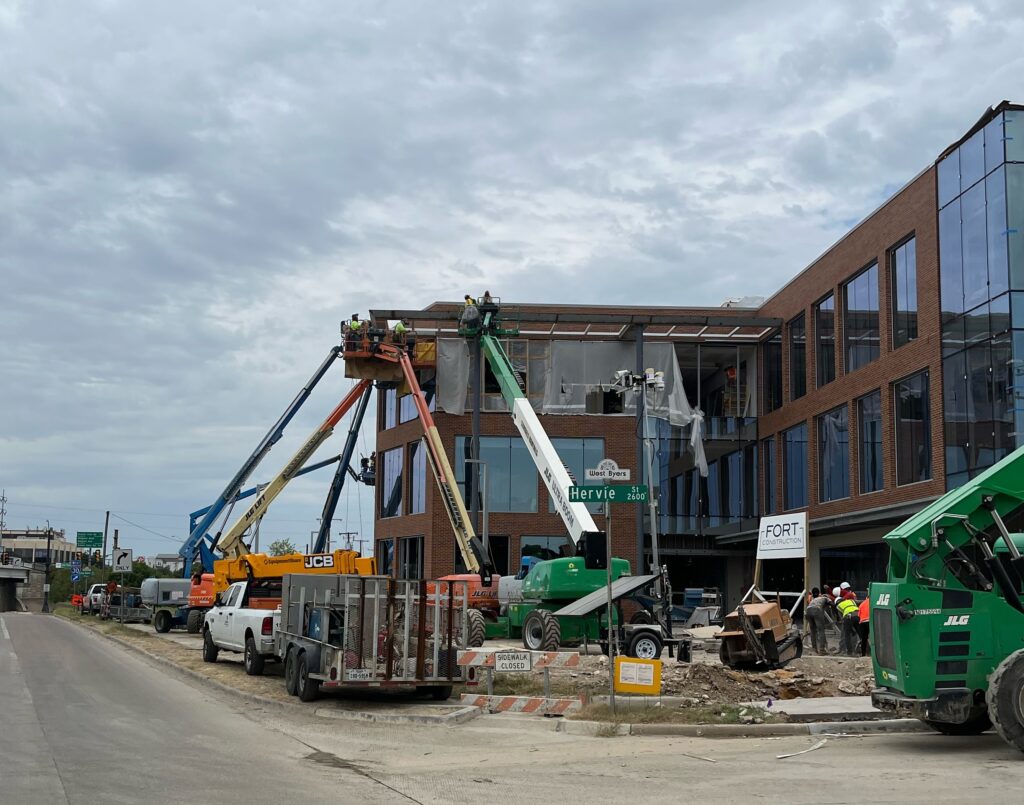 Six boom lifts at The Birchman Office Building in Fort Worth