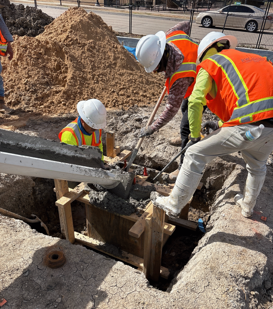 Photo shows construction workers adding square caps to piers at the St Louis Medical Office Building in Fort Worth, Texas